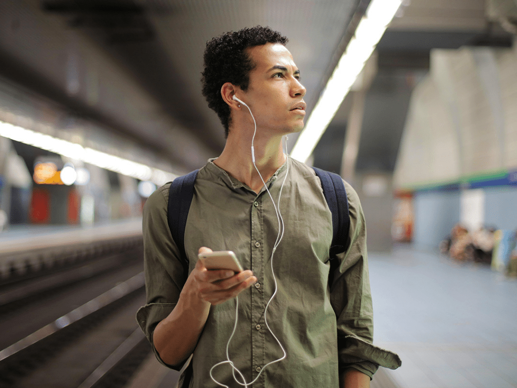 Man listening to music while walking through train station